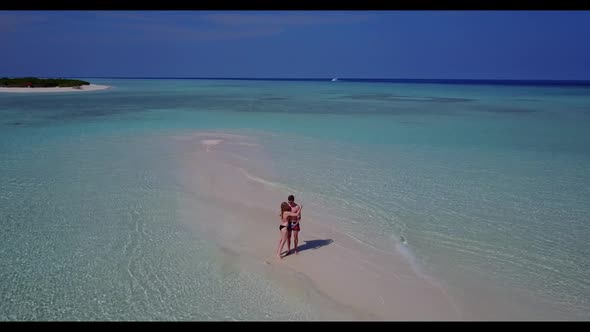 Young couple suntan on perfect tourist beach journey by turquoise lagoon with white sand background 