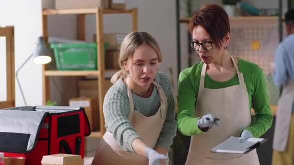 Women Packing Takeaway Food Containers in Delivery Bag
