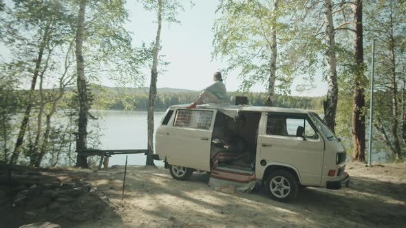 Woman Resting on Roof of Camper Van