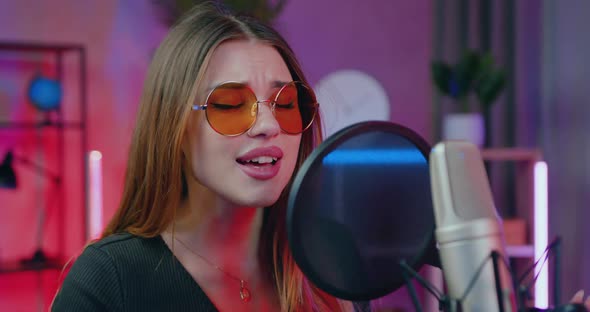 Woman with Long Hair in Sunglasses which Recording Song  in Home Studio