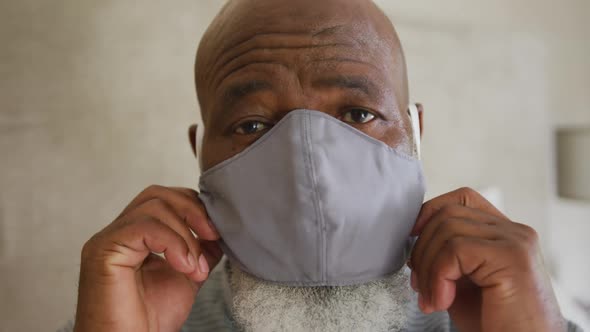 Close-up of portrait of african american senior man wearing face mask at home