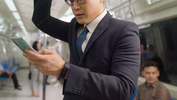 Businessman Using Mobile Phone on Public Train