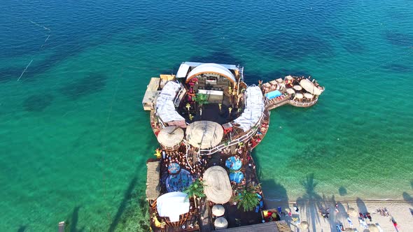 Aerial view of people partying in club on the sea water, Pag island