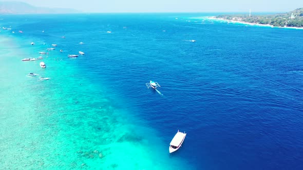 Aerial above landscape of idyllic tourist beach adventure by aqua blue sea and white sandy backgroun