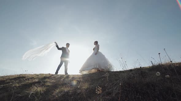 Newlyweds. Caucasian Groom with Bride on Mountain Slope. Wedding Couple. Happy