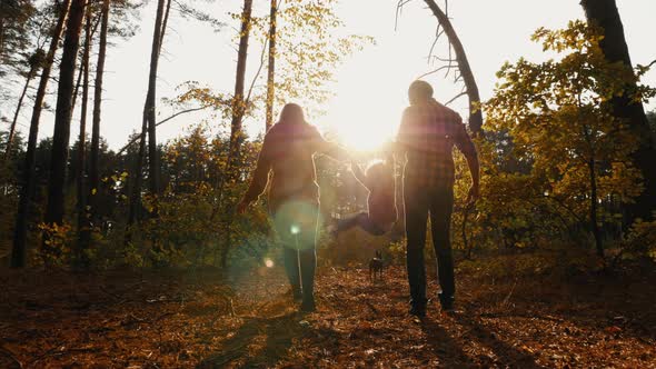 Dad, Mom and Child Are Walking in the Forest