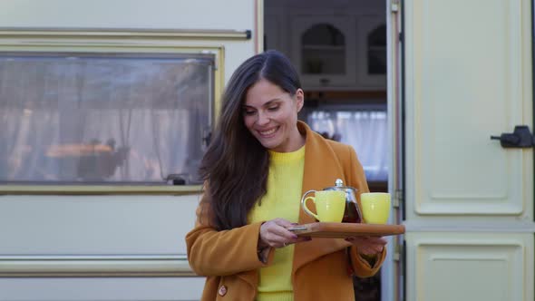 Female Brings Hot Tea To Own with Male Male in Arms Sitting at Table While Walking in Park with