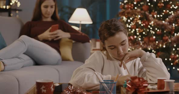 Cute girl writing a Christmas card at home