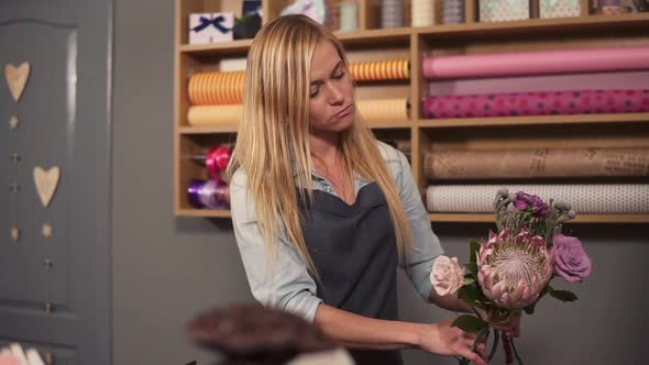 Professional Blonde Female Floral Artist Arranging Beautiful Bouquet at Flower Shop