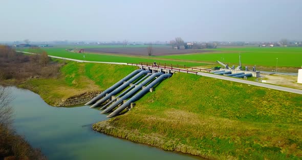 Road Bridge Over Water Supply System Pipes on River By Field