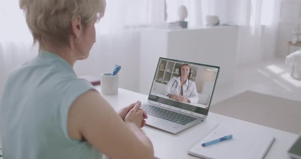 Female Patient Is Calling at Hospital and Talking with Woman Doctor By Video Conference on Laptop