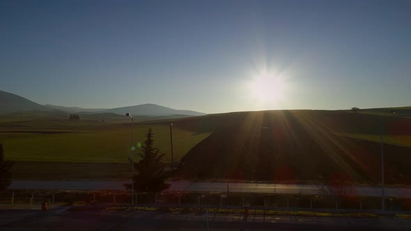 Aerial view of beautiful hills with lots of grass and the sun shining.