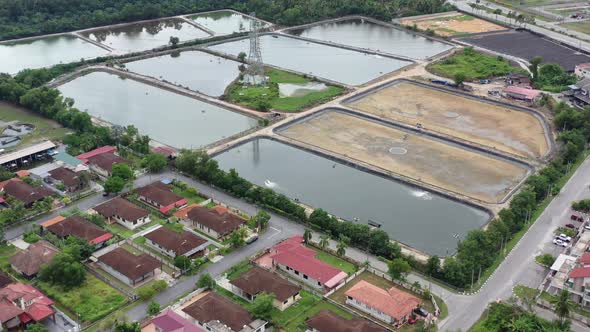 Drone flyover residential neighborhood in manjung, birds eye view overlooking at surrounding aquacul