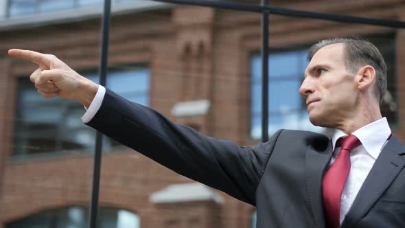 Confident Businessman Pointing with Finger to Aim