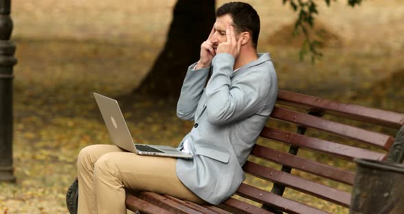 Stressed young man having painful head feelings due to computer overwork.