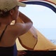 Woman unzips the tent inside and looks at sea stretching her arms in morning. - VideoHive Item for Sale