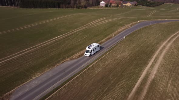 Tracking Shot of a Traveling White Camper Van Taken With a Flying Drone