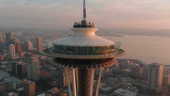 Zoomed in aerial of the Space Needle during sunset with Seattle's downtown skyscrapers in the backgr