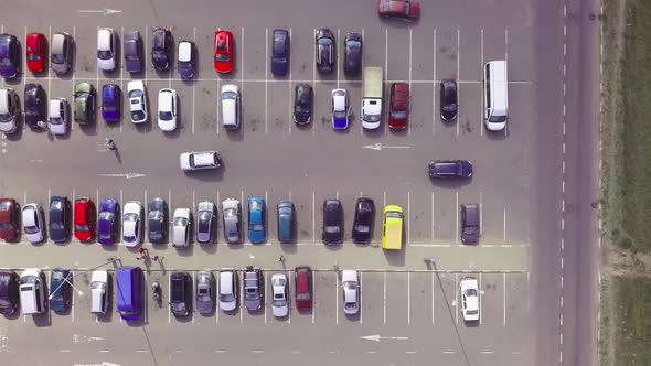 A bird's-eye view of parked cars in the parking lot near the shopping center.