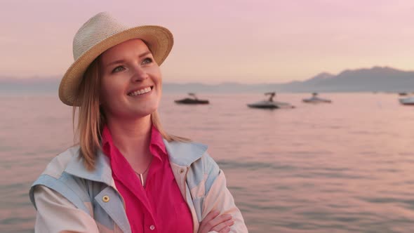 Beautiful Smiling Young Caucasian Woman with Pretty Face Looking at Pink Sunset