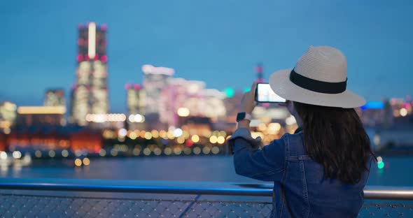 Woman take photo with cellphone in Yokohama city at night