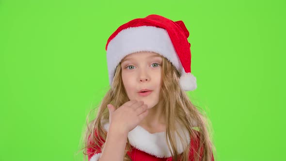 Baby Girl in Red Christmas Caps Send Air Kisses. Green Screen