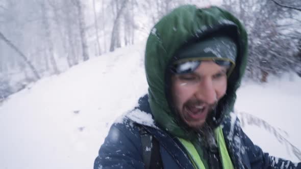Portrait of Happy Climber with Backpack at Snowfall