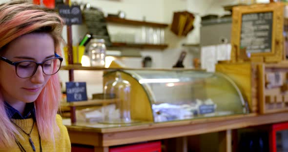 Young woman using laptop in cafe 4k