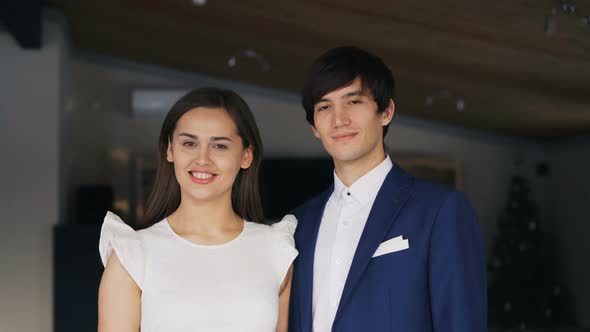 Portrait of Beautiful Young Couple Man and Woman in Fancy Clothing Standing Together in Restaurant