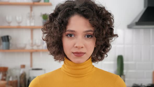 Close Up Face Hispanic Curly Woman Looking Camera Standing at Home Kitchen