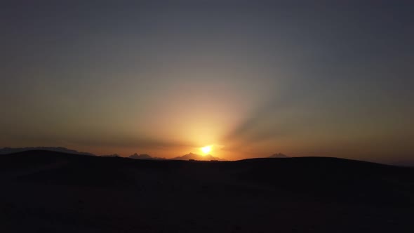 Beautiful Sunset in the Desert Against the Background of Mountains