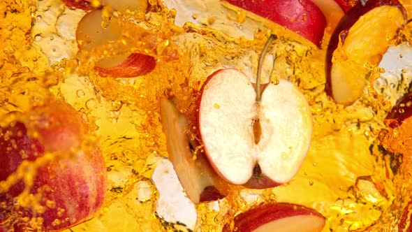 Super Slow Motion Shot of Red Apple Cuts Falling and Splashing Into Juice at 1000Fps