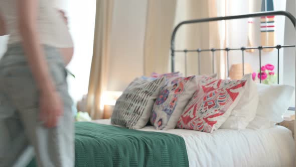 Pregnant Woman Coming and Sitting on Bed