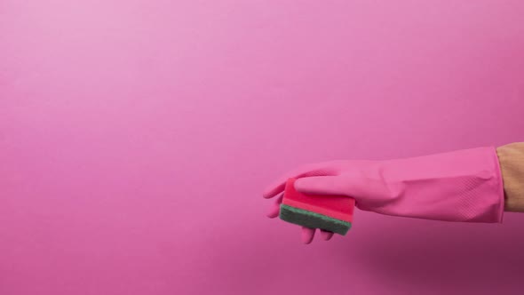 Right Hand in a Pink Glove with a Sponge for Washing Dishes