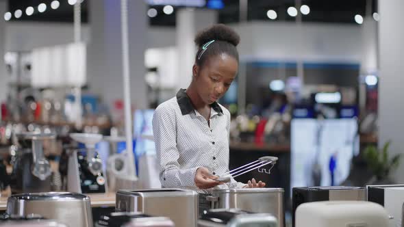 Female Shopper is Choosing Toaster Viewing Exhibition Samples Woman is Shopping in Kitchen