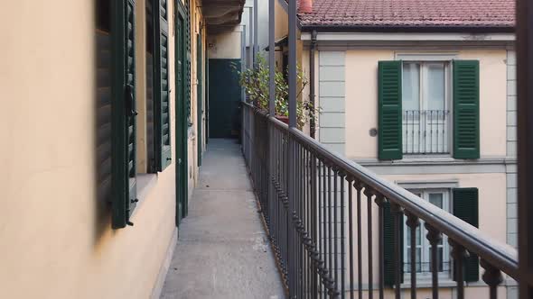 A resident of the house walks along a narrow Italian balcony-terrace. 