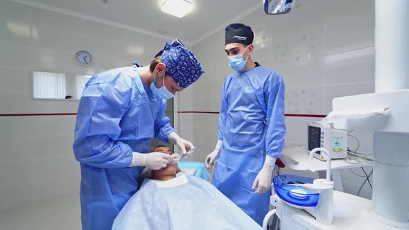 Modern dental surgery. Dentist surgeon with assistant during dental surgery