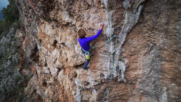 Strong Girl Rock Climber Climbs on Overhanging Crag