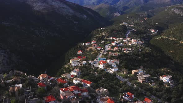 Aerial of historic old town of Himara amidst huge steep mountains of Ceraunian, Albania.