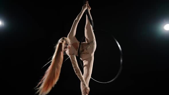 Slim Flexible Gymnast Performing French Gazelle on Air Hoop in Slow Motion