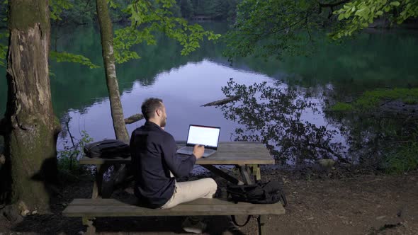 Businessman talking by phone in nature.