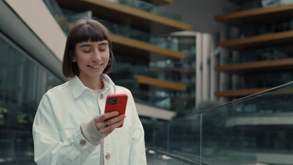 Woman Standing Outdoors and Using Cell Phone for Purchases