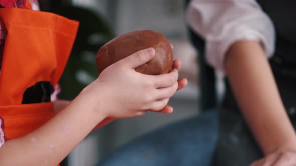 Closeup of Woman and Little Girl Working in Pottery Workshop