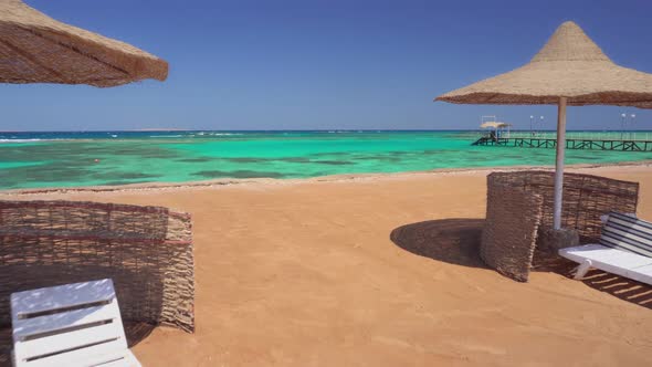 Beach with Umbrellas and Sun Loungers Against the Backdrop of a Beautiful Azure Sea