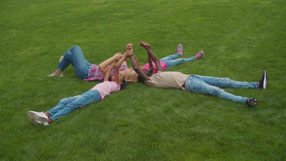 Joyful Multiethnic Family Lying on Grass in Circle