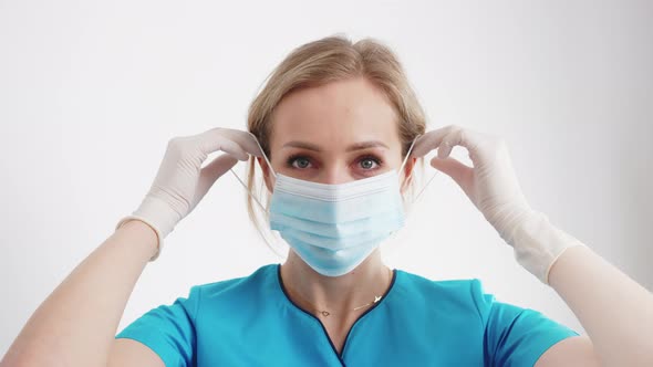 Responsible Caucasian Female Doctor Puts on Her Protective Mask Before Surgery