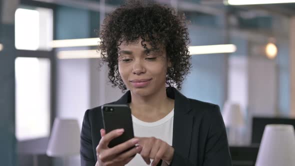 Portrait of Cheerful African Businesswoman Using Smartphone