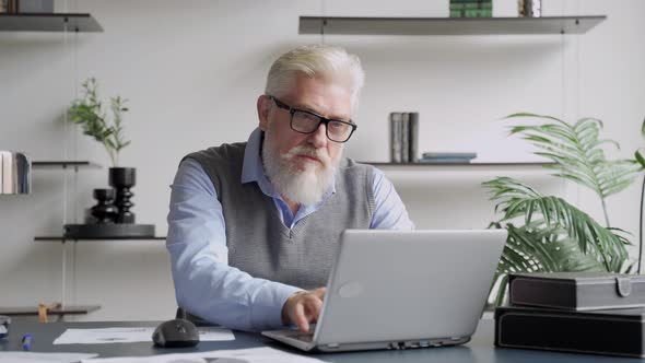 Happy an Elderly Man with a Gray Beard Completed Task and Triumphing with Raised Hands