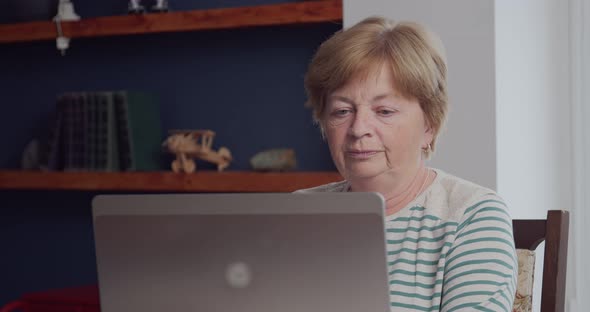 An Elderly Woman is Talking Via Video Communication Via a Laptop