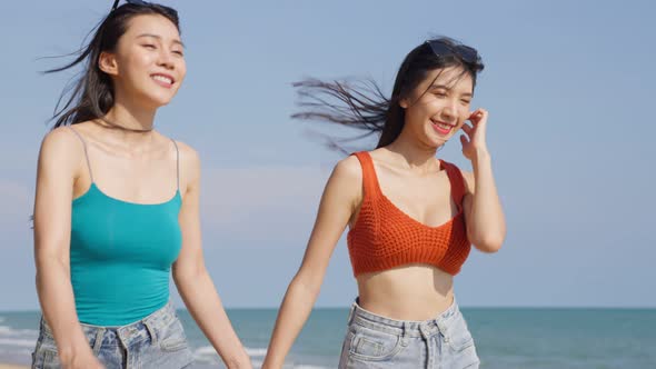 Asian young beautiful woman friends walking on the beach during summer on holiday vacation.